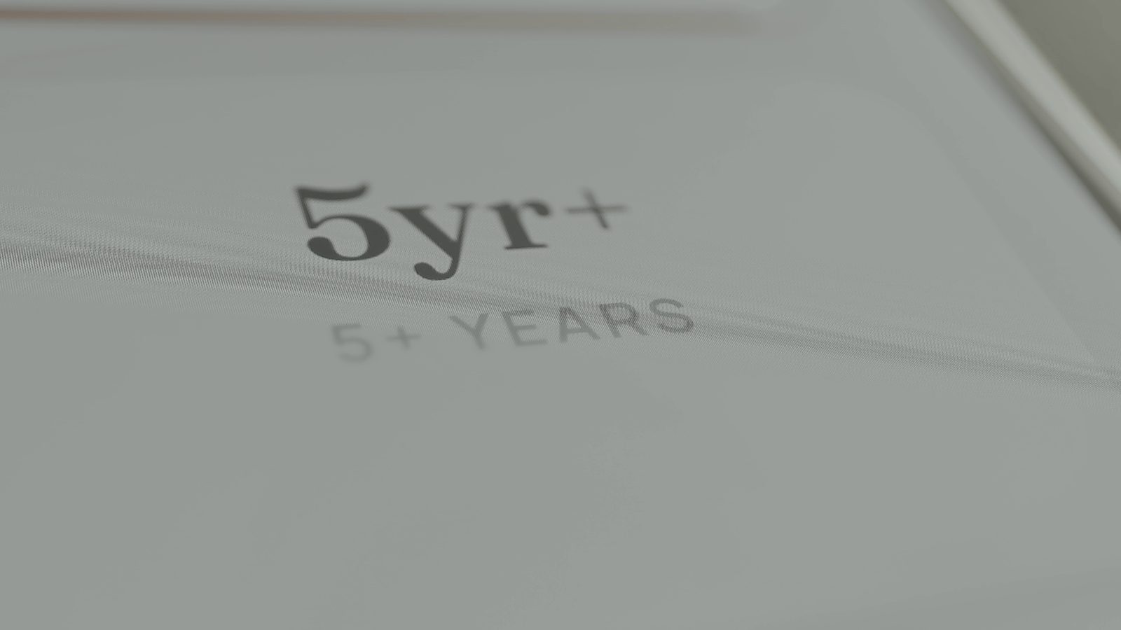 Close-up of a light grey printed card reading 5yr+ and 5+ years